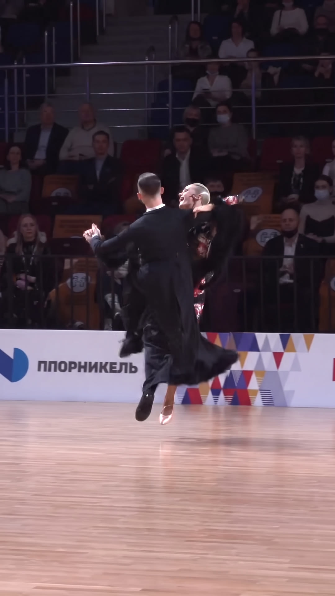 Ballroom couple airborne mid-jump during a Quickstep